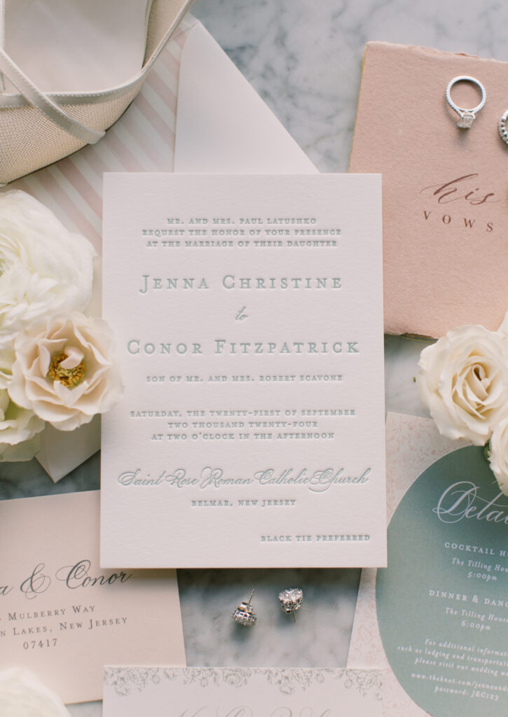 Wedding invitation suite with floral accents, featuring names Jenna Christine and Conor Fitzpatrick, and details for a wedding ceremony at Sacred Rose Roman Catholic Church in New Jersey.